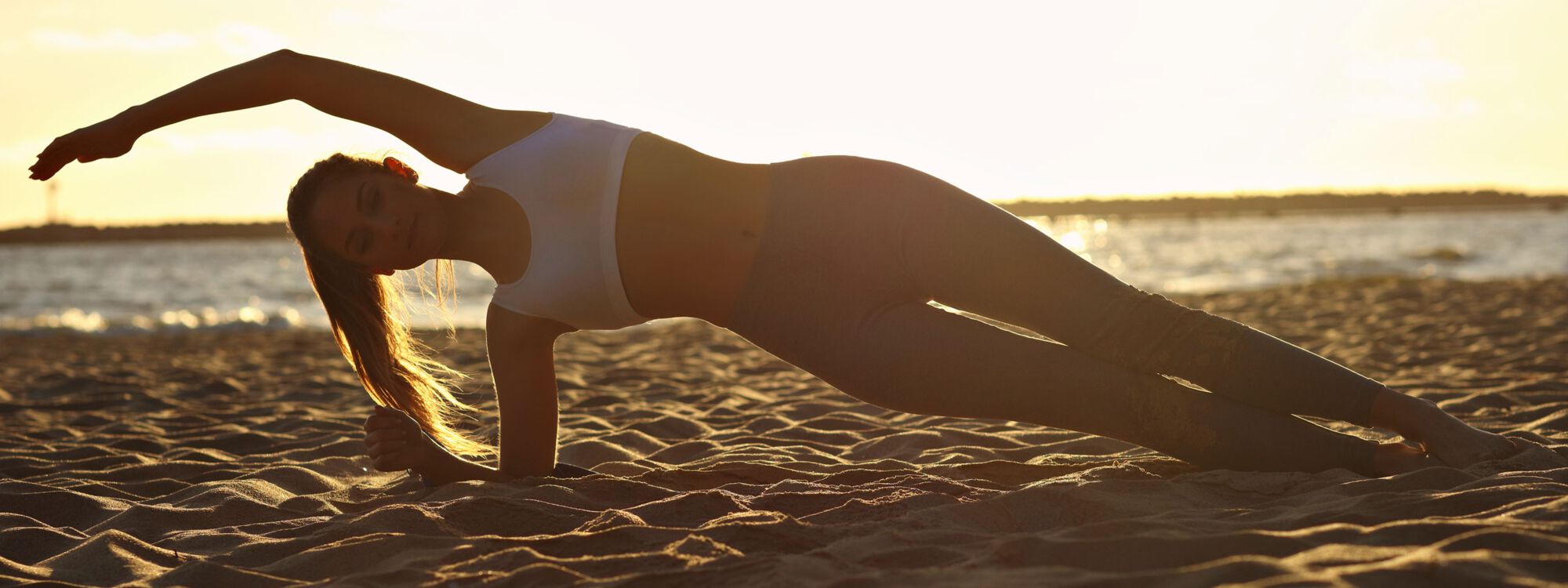 Yoga bei Sonnenaufgang am Ostseestrand